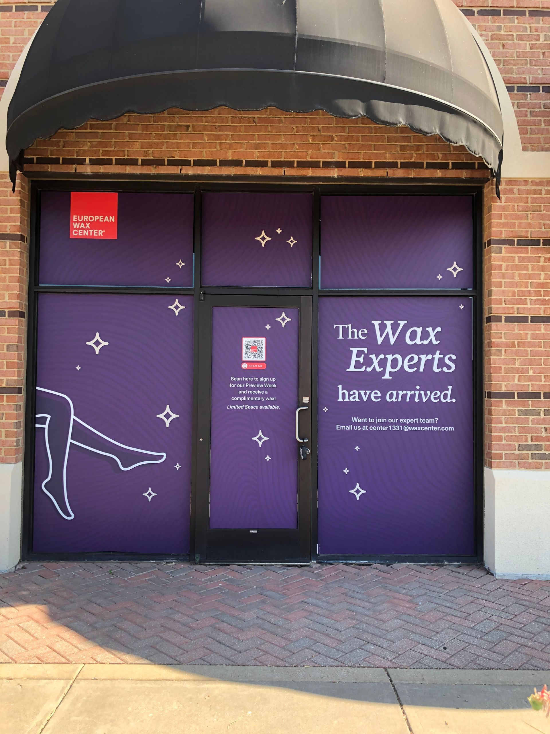 Purple storefront with “The Wax Experts have arrived” on the window under a black awning