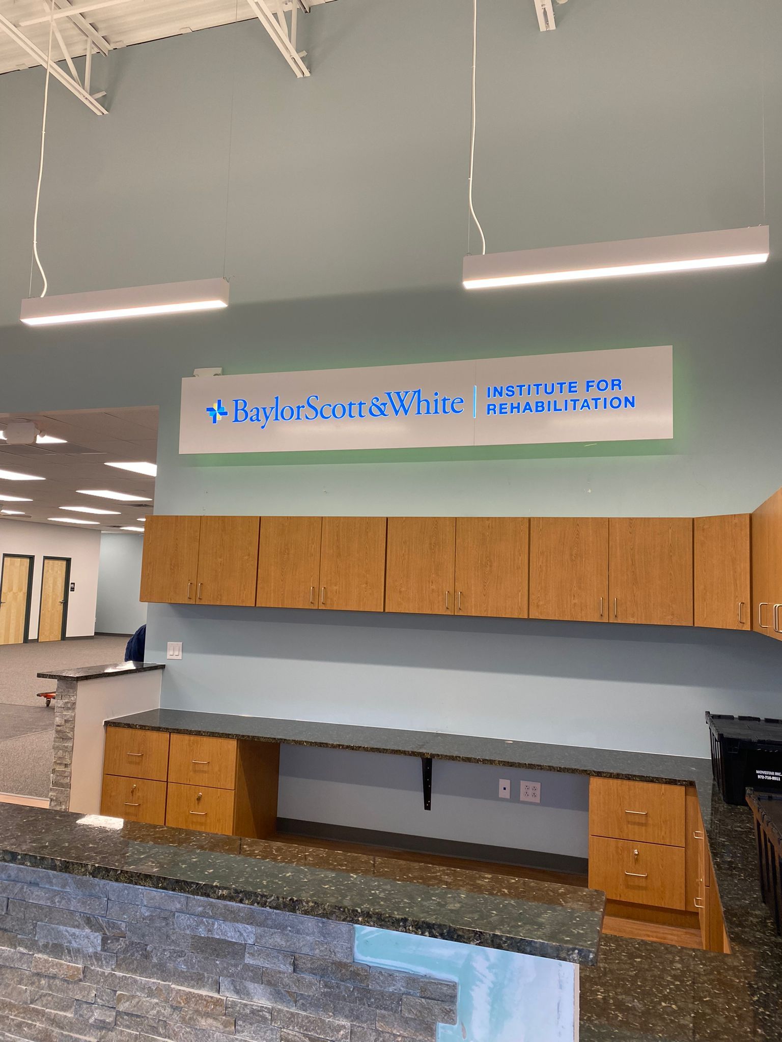 Lab with wooden cabinets, gray countertops, and a sign above the workspace.