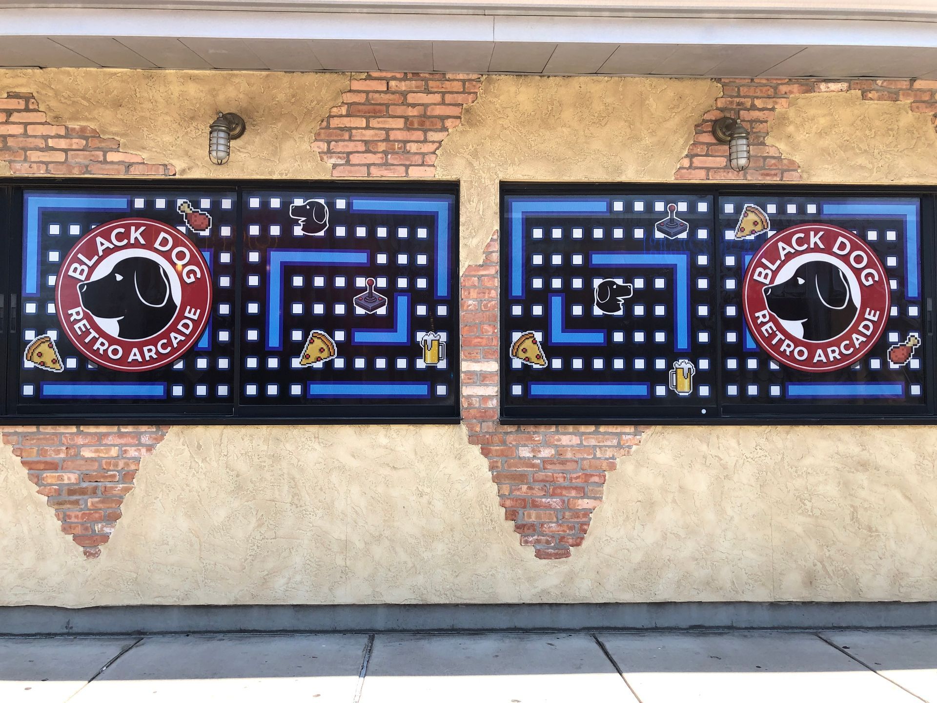 Black Dog Coffee mural with black, blue, and red maze panels on a brick wall