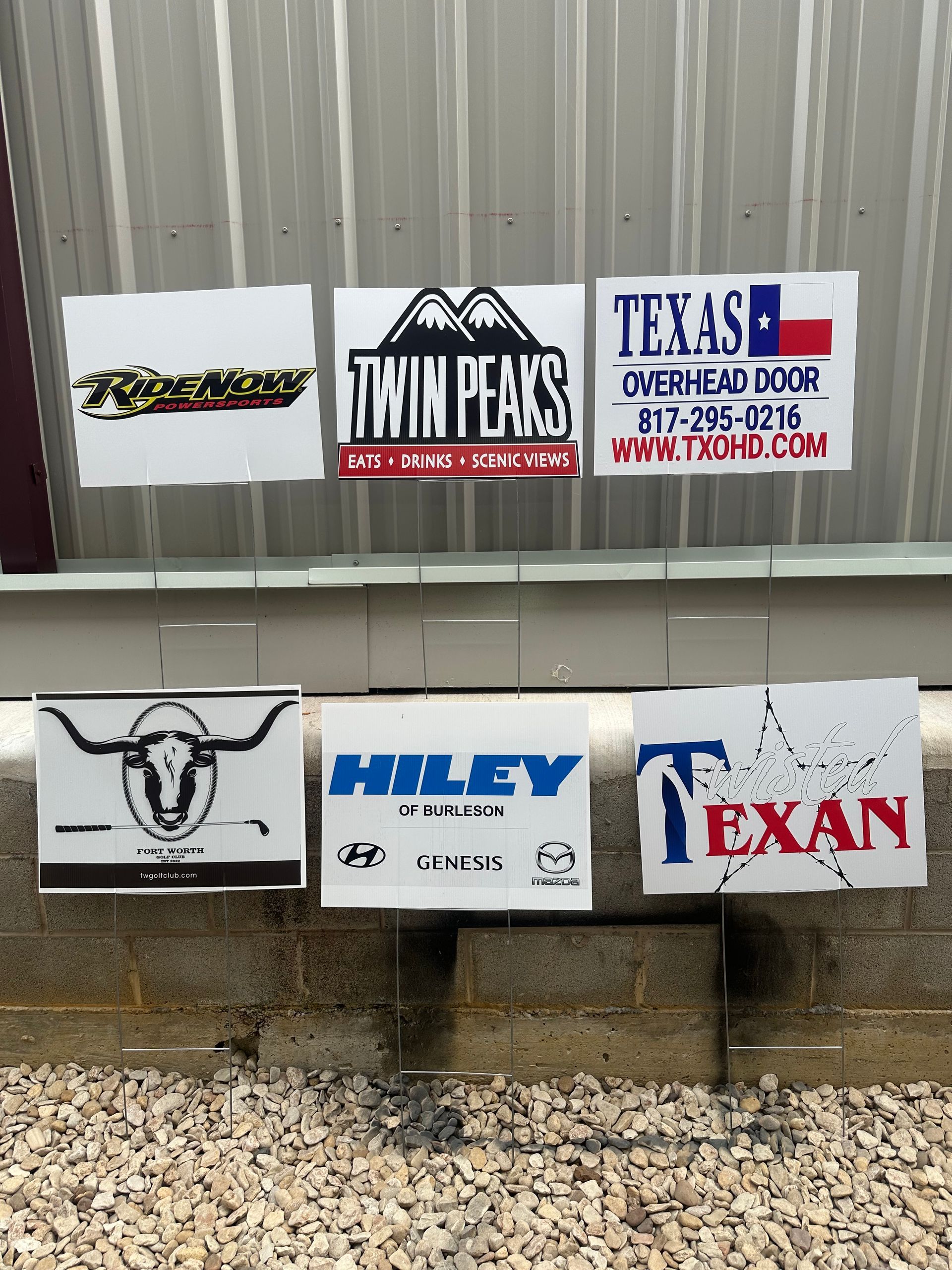 Cloth panels with logos for Twin Peaks, Texas, Hiley, and a bull on a fence in front of a metal wall