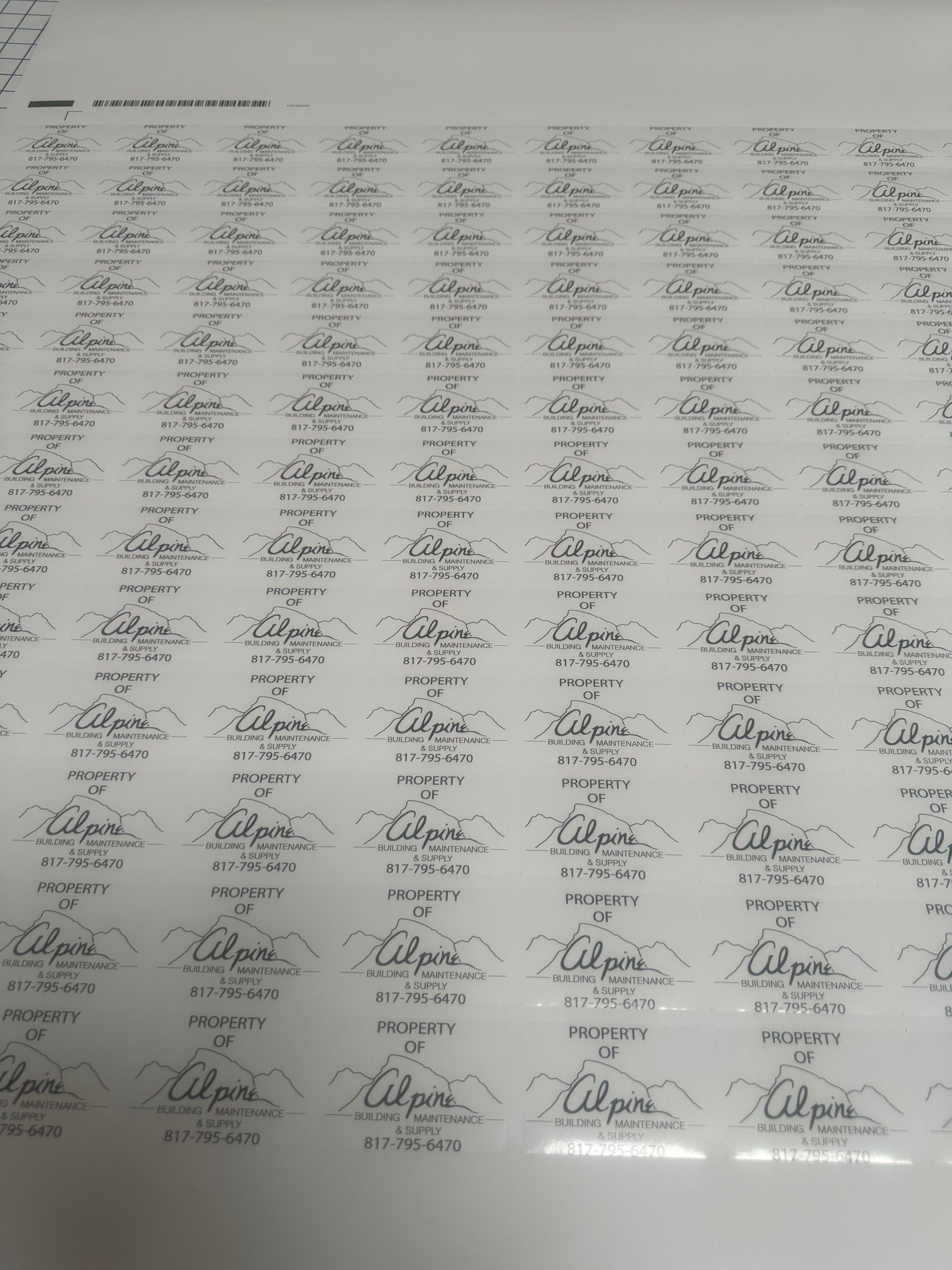 A sheet filled with a grid of many repeated handwritten signatures, slightly blurry and photographed at an angle.