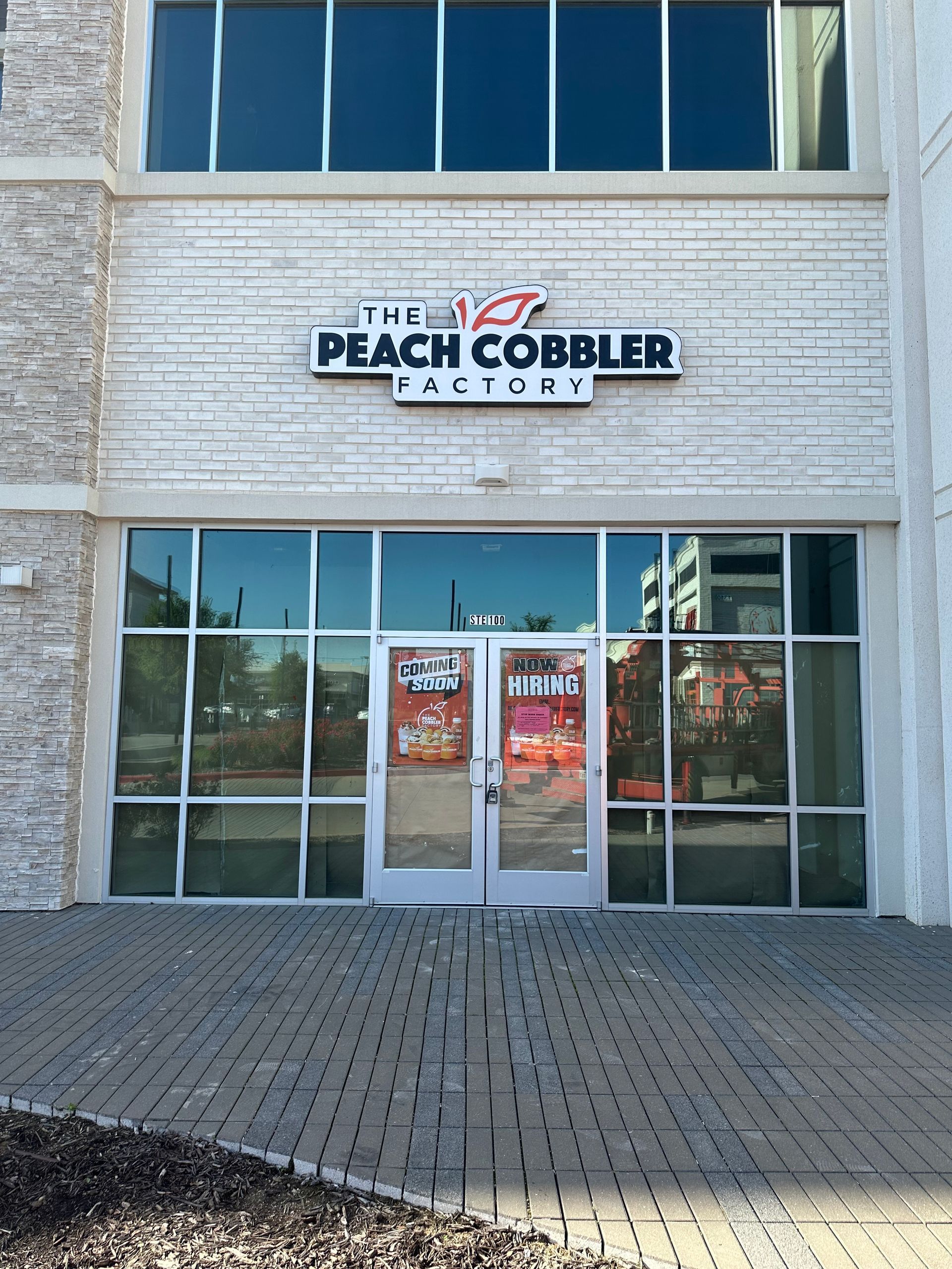 The Peach Cobbler Factory storefront with glass doors and windows on a brick facade