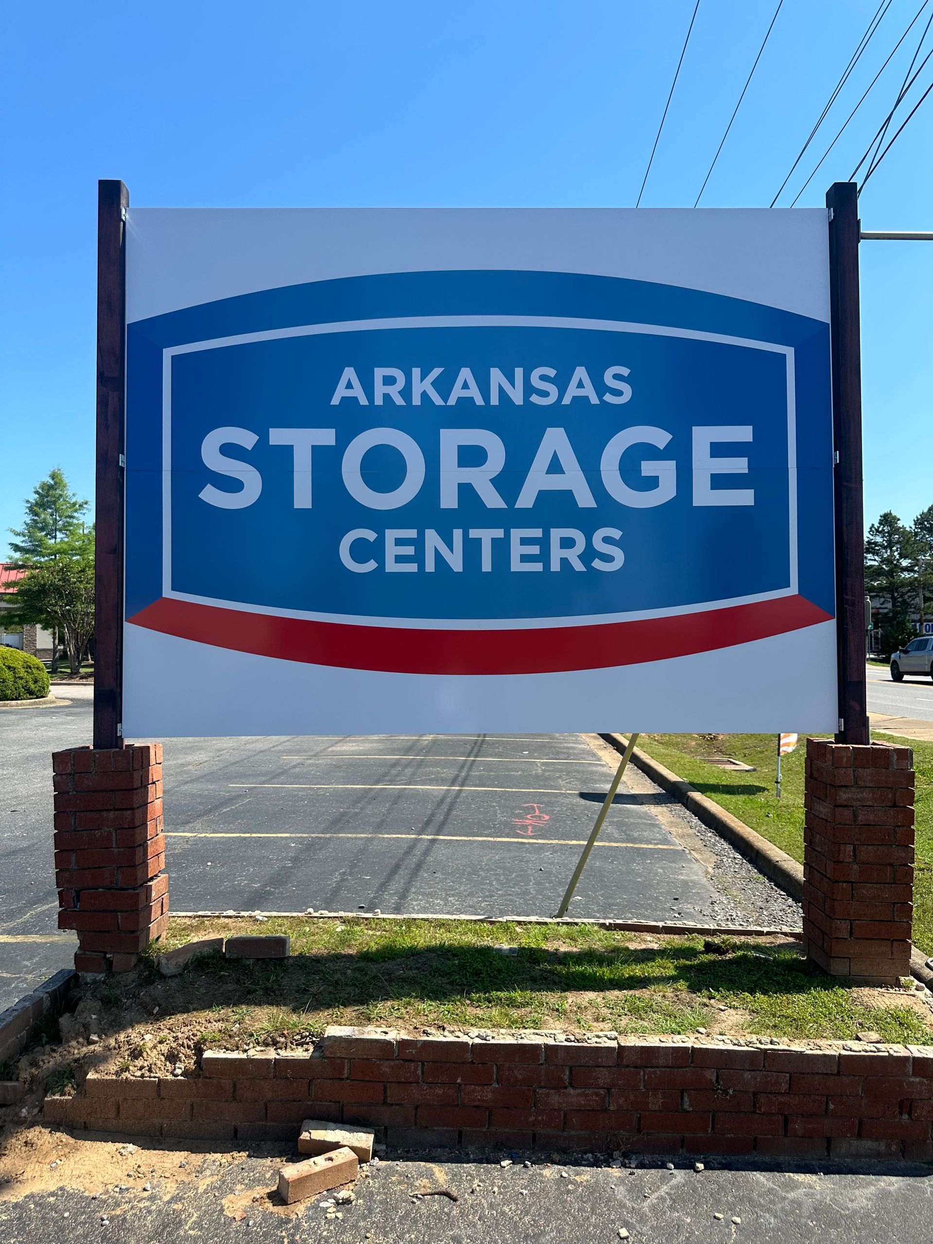 Arkansas Storage Centers sign on blue background with red stripes, mounted on brick posts outdoors