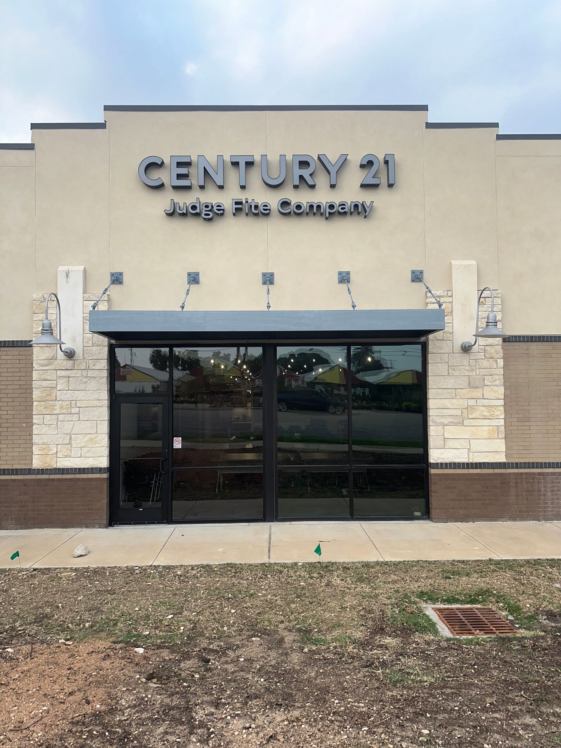Century 21 Judge Fite Company storefront with glass doors and stone facade