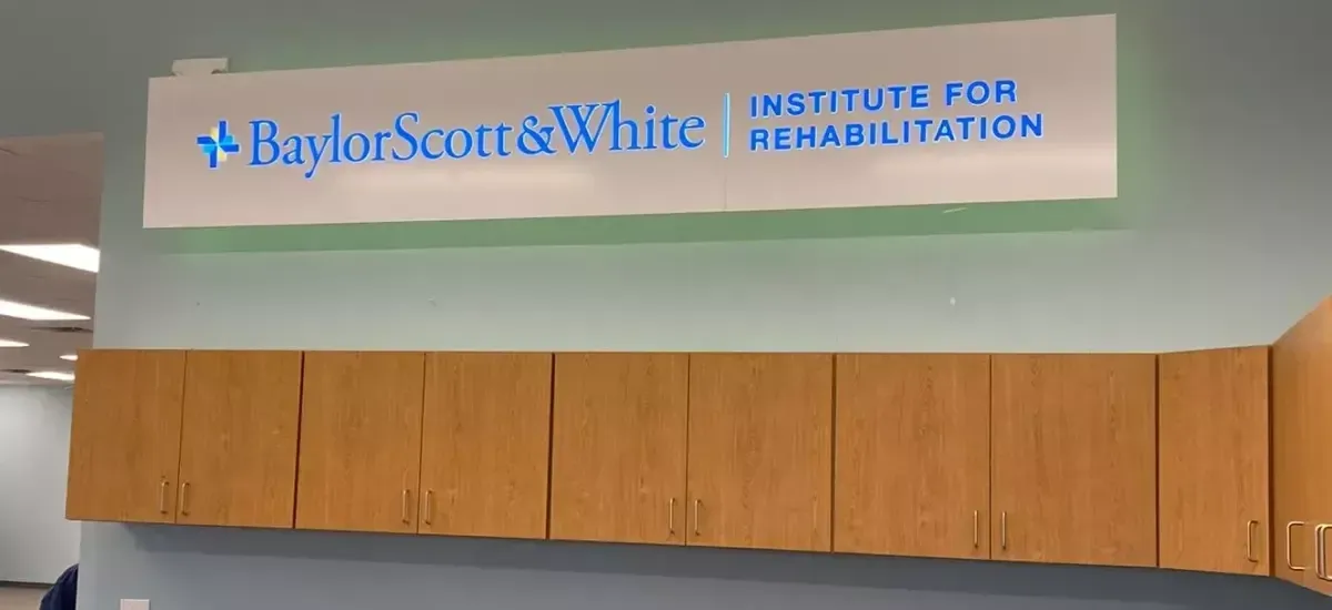 Baylor Scott & White Institute for Rehabilitation sign above wooden wall cabinets