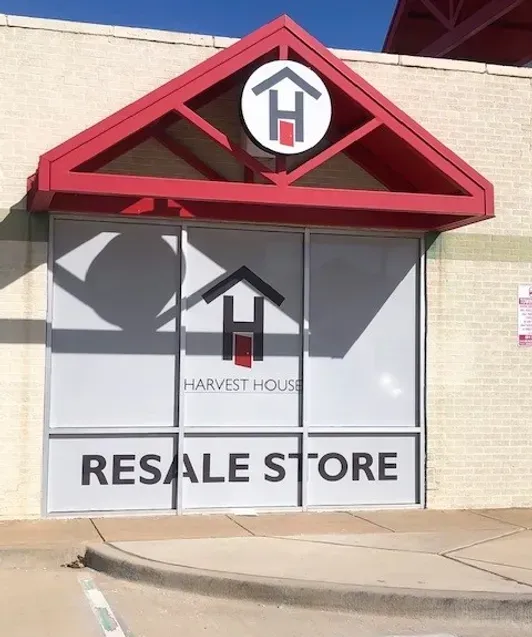 Harvest House Resale Store storefront with red awning and large window signs