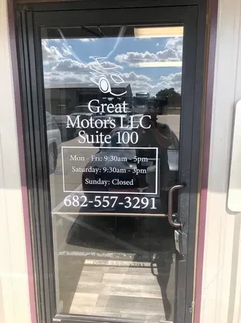 Glass door sign for Great Motors LLC Suite 100 with hours and phone number 682-557-3291