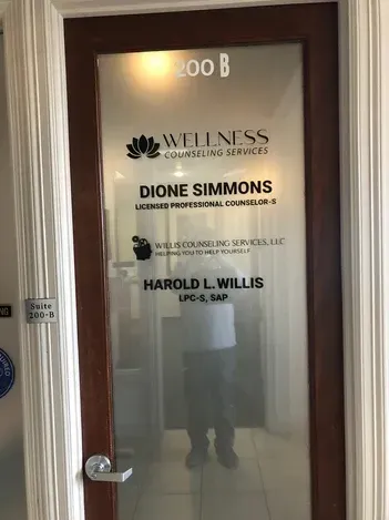 Glass office door with frosted branding for Wellness, listing Dione Simmons and Harold L. Willis, room 200B