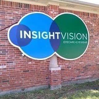 Blue and green Insight Vision eyecare sign on a brick wall