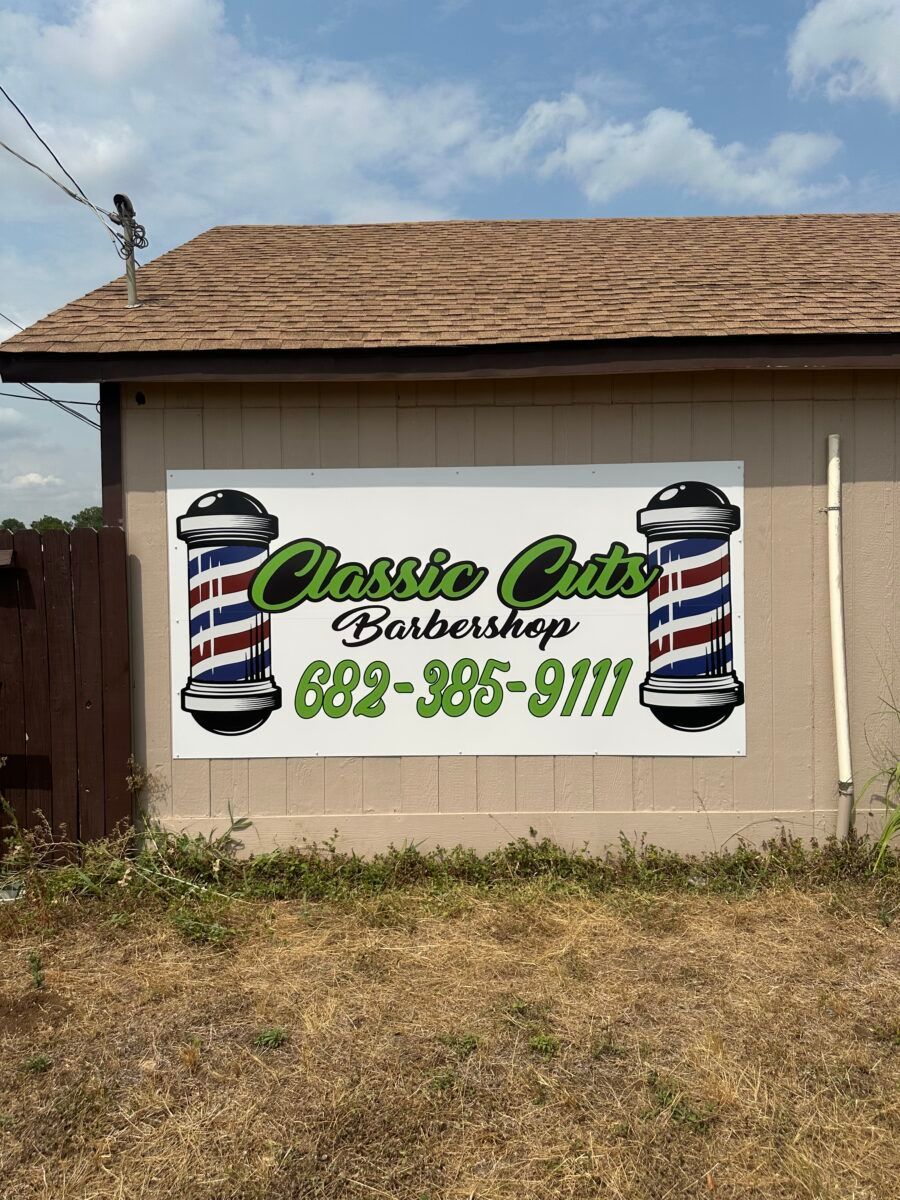 Classic Cuts Barbershop sign on a beige building with barber poles and phone number 892-365-8111