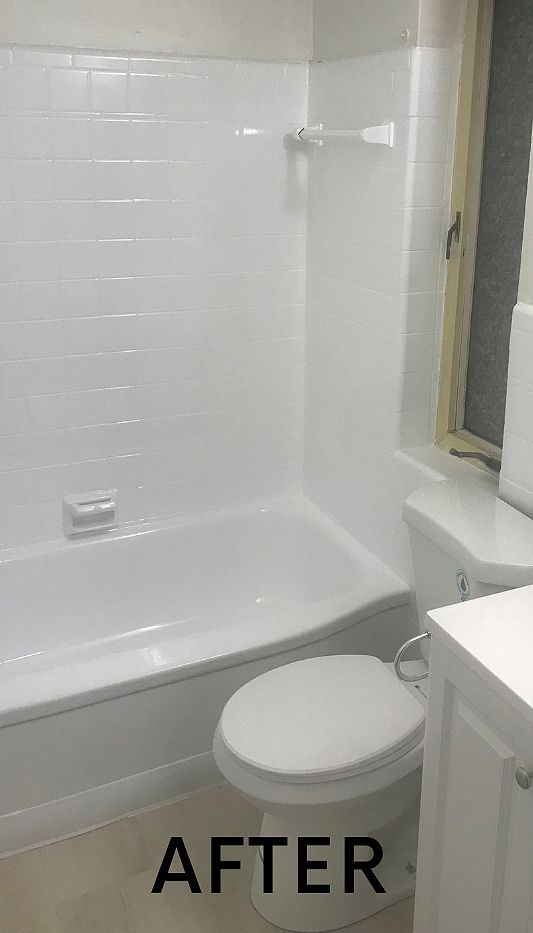 A bathroom with a bathtub, toilet, sink and window.