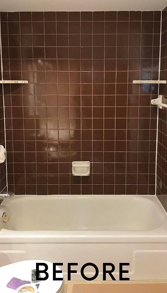 A before picture of a bathroom with brown tiles and a bathtub.