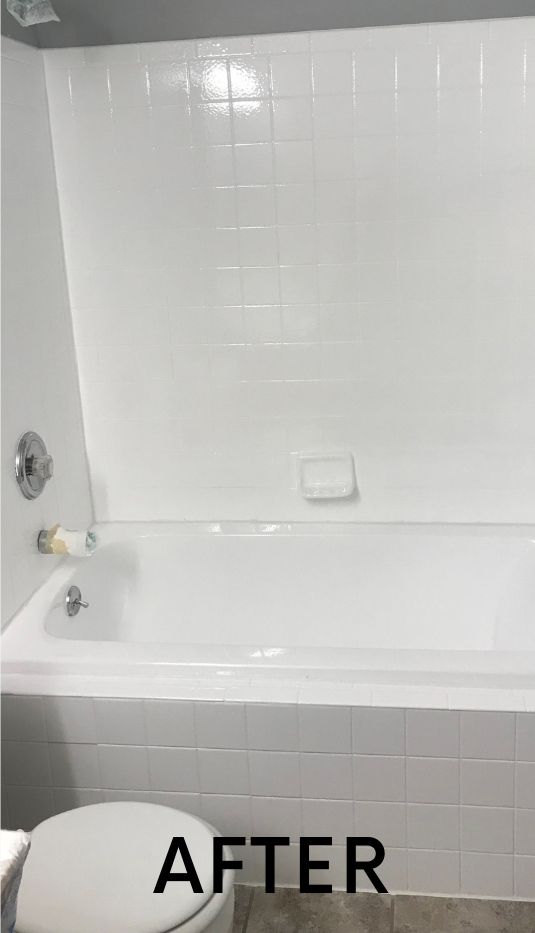 A bathroom with a bathtub and toilet after being painted white.