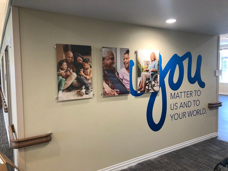 Wall with three framed photos and large blue text reading 