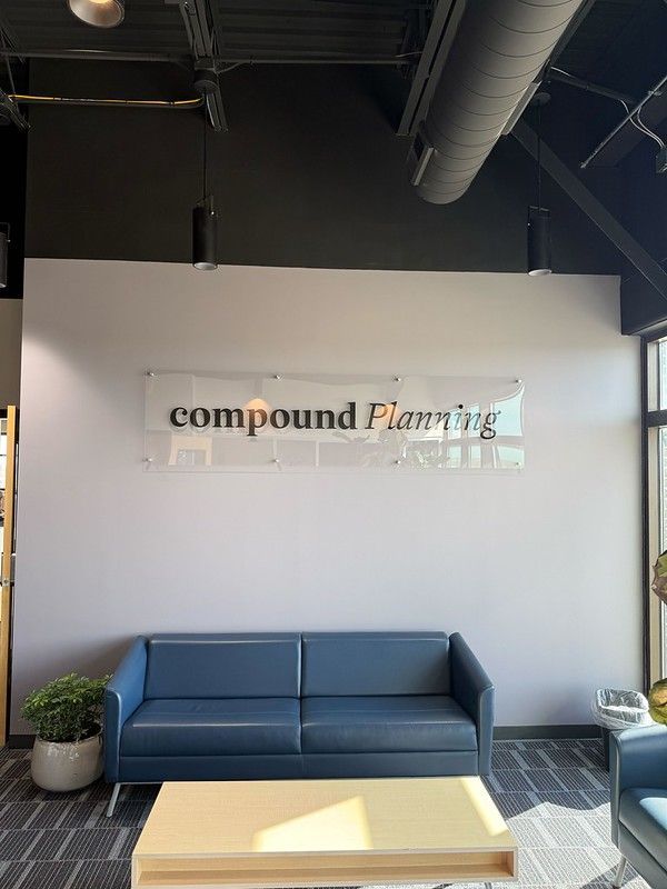 A blue sofa and light wood coffee table sit in a waiting area with a 