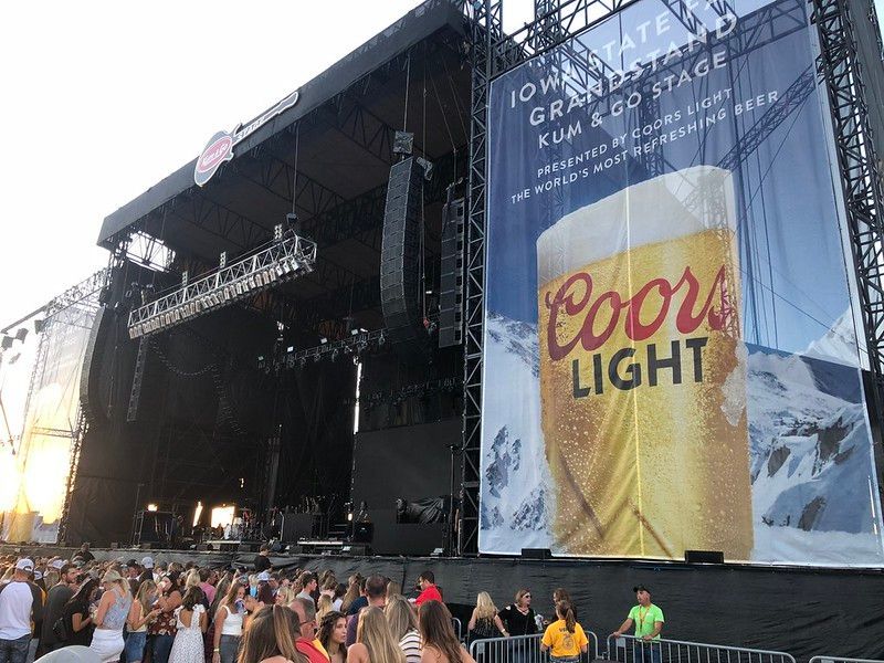 A concert stage at the Iowa State Fair with a large Coors Light banner beside a crowd of people.