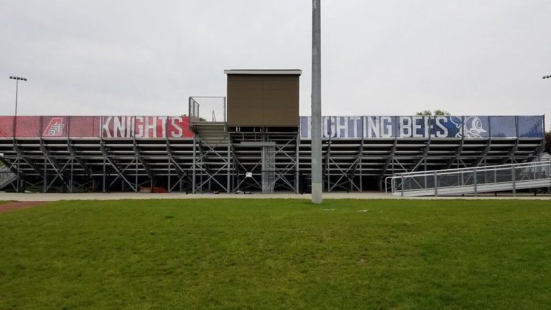 Outdoor metal stadium bleachers with a central press box, featuring 