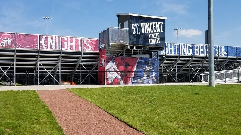 Metal stadium bleachers with a central press box branded 
