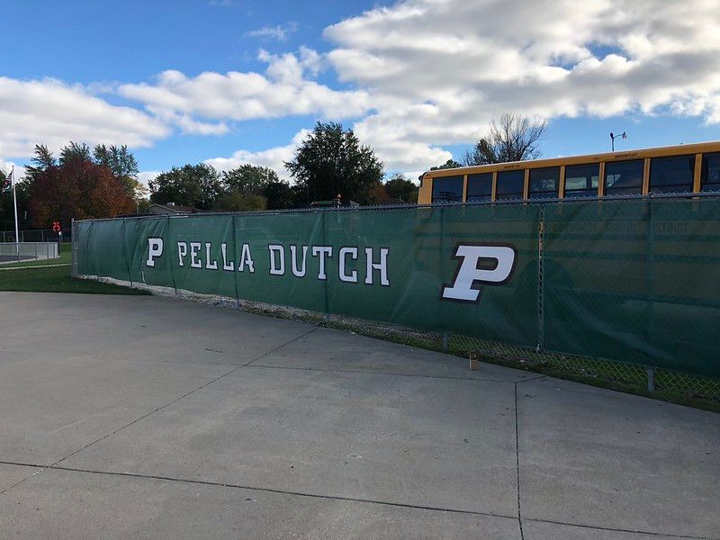 A green fence screen with white text reading 