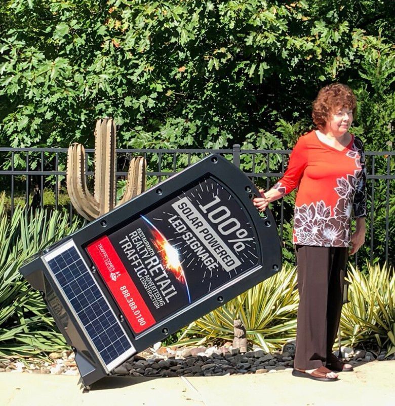 A person stands outdoors, holding an angled 