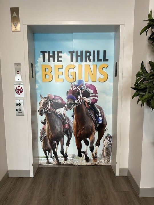 Elevator doors wrapped in a horse racing graphic with the text 