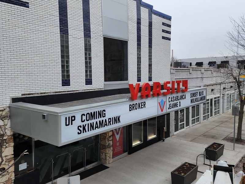 A white brick Varsity Theater building exterior with a marquee listing films including Skinamarink, Casablanca, and Broker.