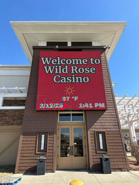 The entrance to the Wild Rose Casino, featuring a large red electronic sign displaying the date, time, and temperature.