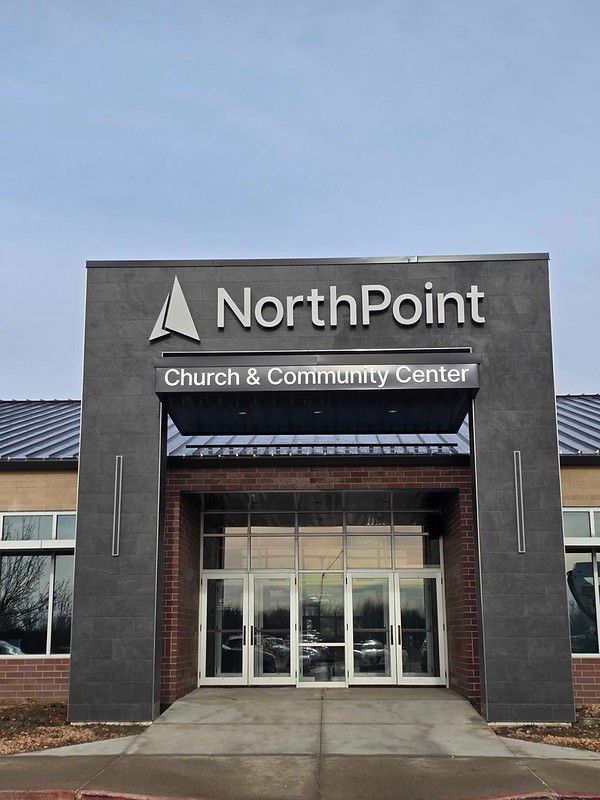 The entrance to NorthPoint Church & Community Center, featuring a dark stone facade and glass double doors.