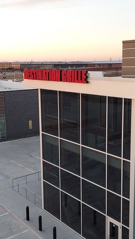 A modern building with a large glass facade featuring a red 