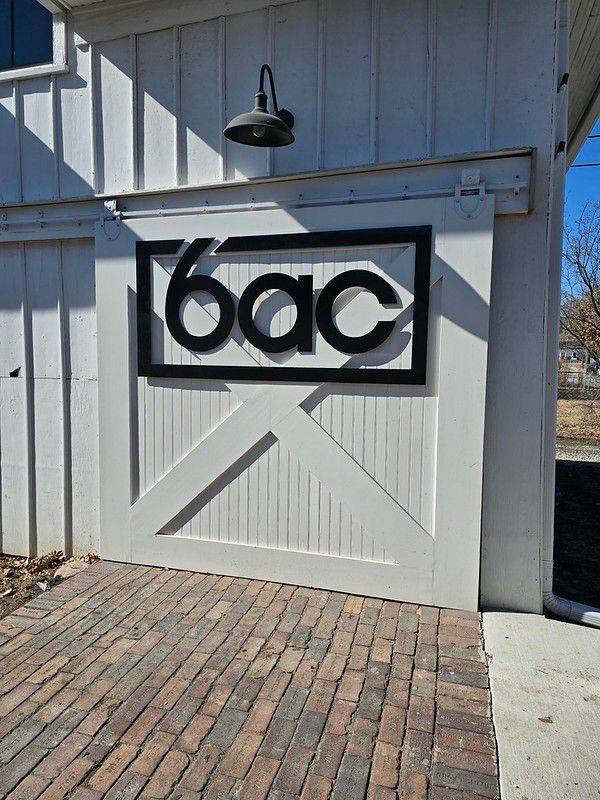 A white barn-style door with a black rectangular sign reading 