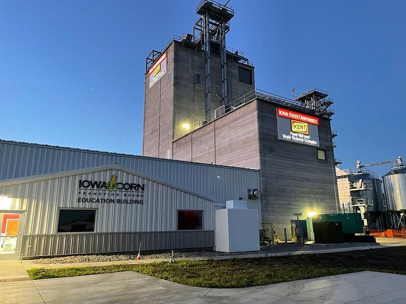 The Iowa Corn Education Building with its tall concrete grain silo exterior under a clear blue sky.