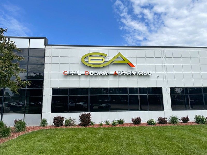A modern office building with a white exterior, a green and yellow 