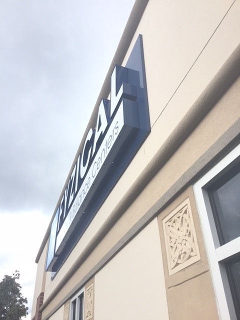 Angled shot of a building exterior with a blue sign reading 