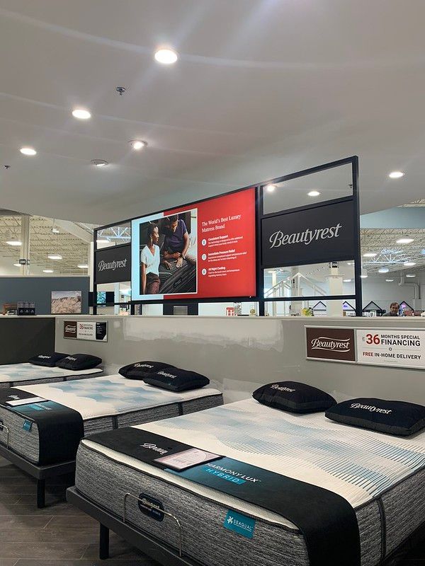 A mattress showroom featuring Beautyrest branding with displays of bed sets in a clean, modern store environment.