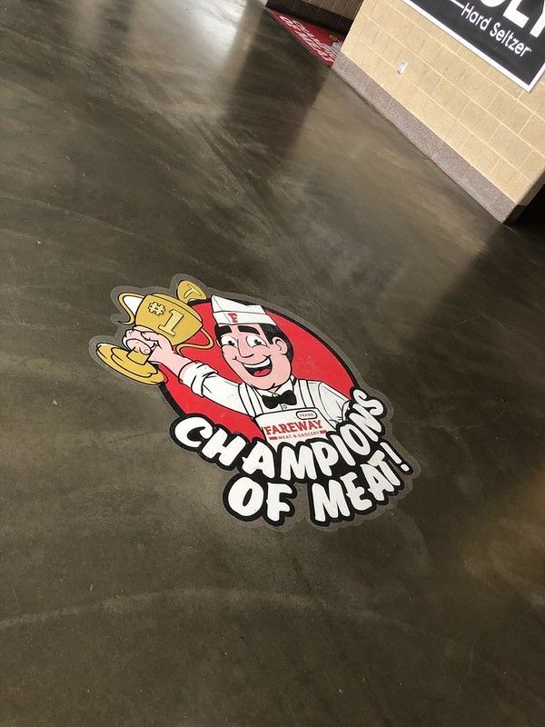 A floor decal featuring a cartoon butcher holding a gold trophy with the text 