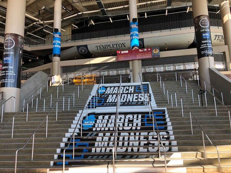 Concrete stadium stairs decorated with blue and white NCAA March Madness logos.