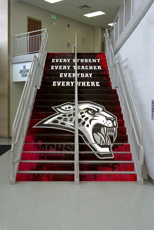 A school staircase featuring red and black gradient steps, a jaguar mascot, and the text 