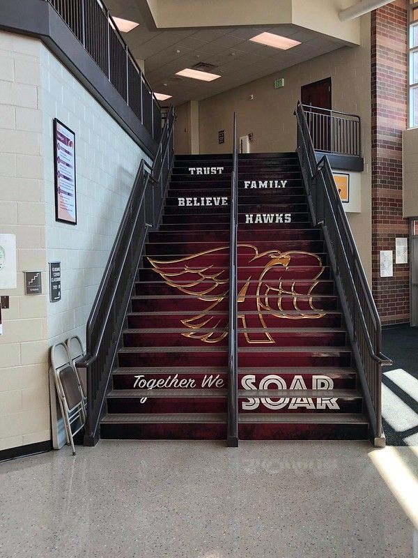 Staircase with maroon steps featuring a hawk mascot, text reading 