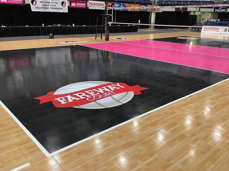 A volleyball court with a black playing area featuring a 