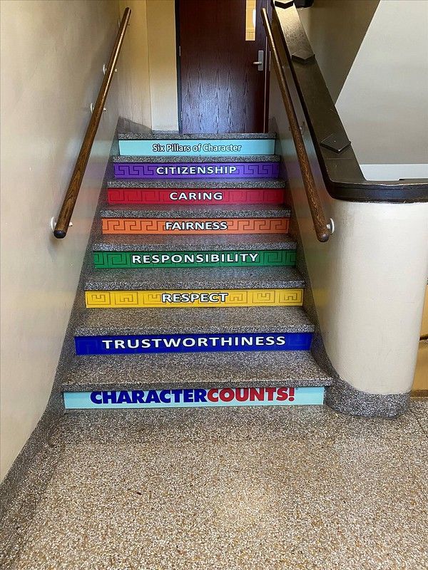 A staircase with colorful steps labeled with character traits like Respect, Responsibility, and Trustworthiness.