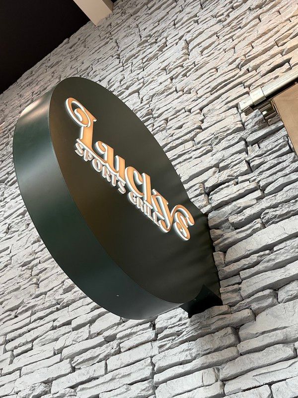 A black, oval-shaped sign for 