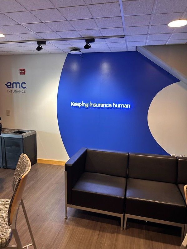 Waiting area with a black leather sofa against a blue accent wall featuring the white text 