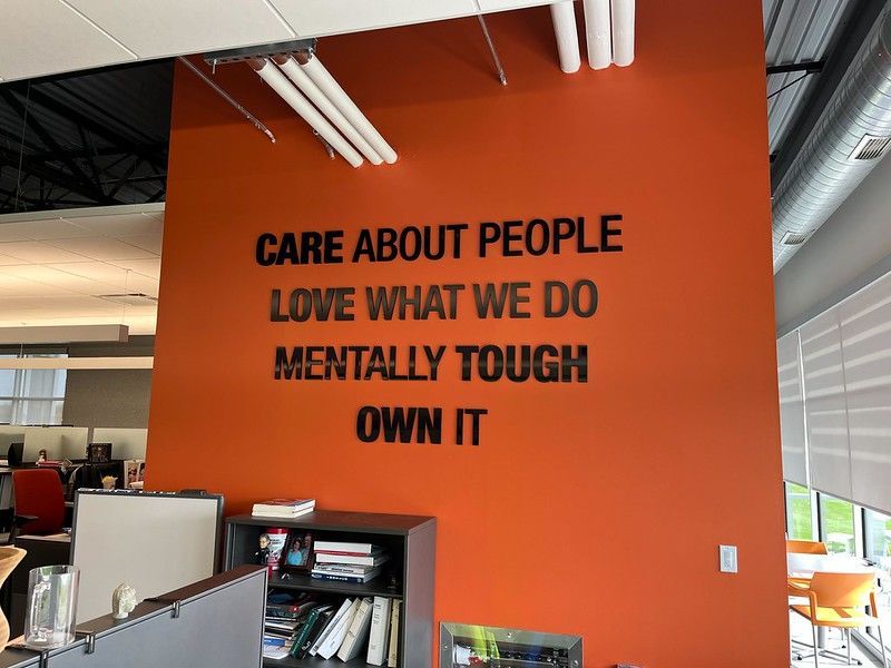 An orange office wall with the black text: 