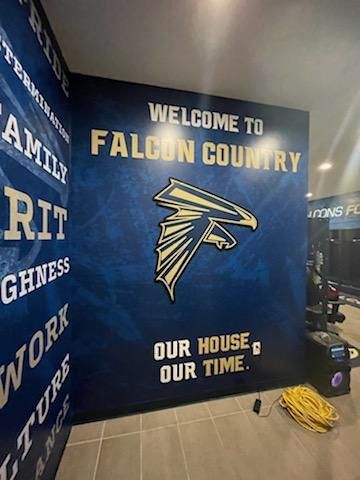 A wall featuring a gold falcon logo, 