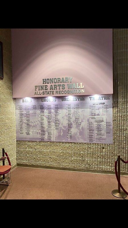 Honorary Fine Arts Wall with lists of All-State recognition in a dimly lit hallway with rope barriers.
