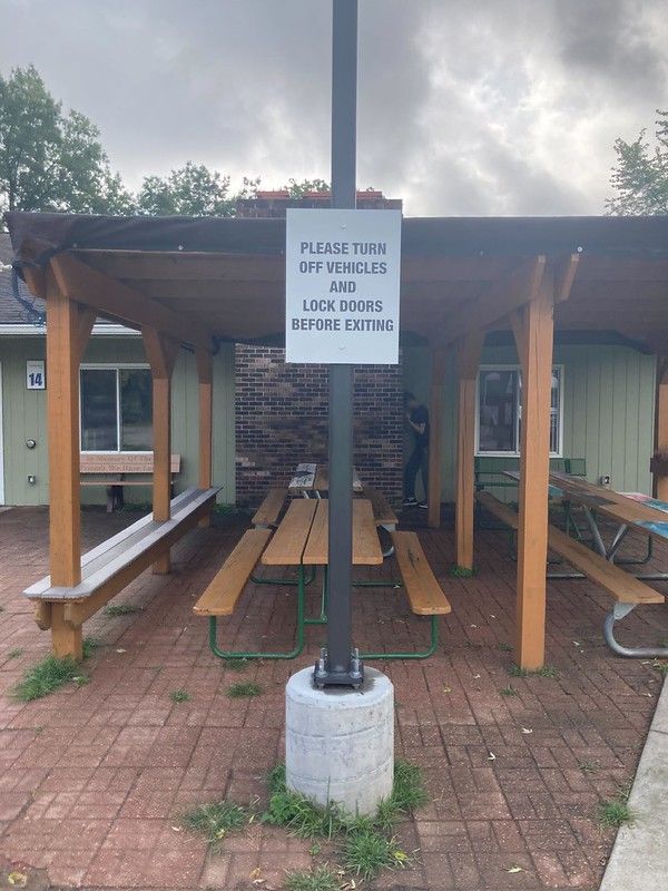 A pavilion with picnic tables and a sign that reads: 
