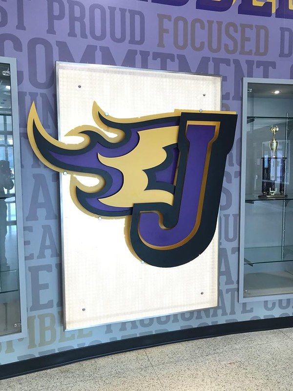 A large, stylized purple and gold letter 