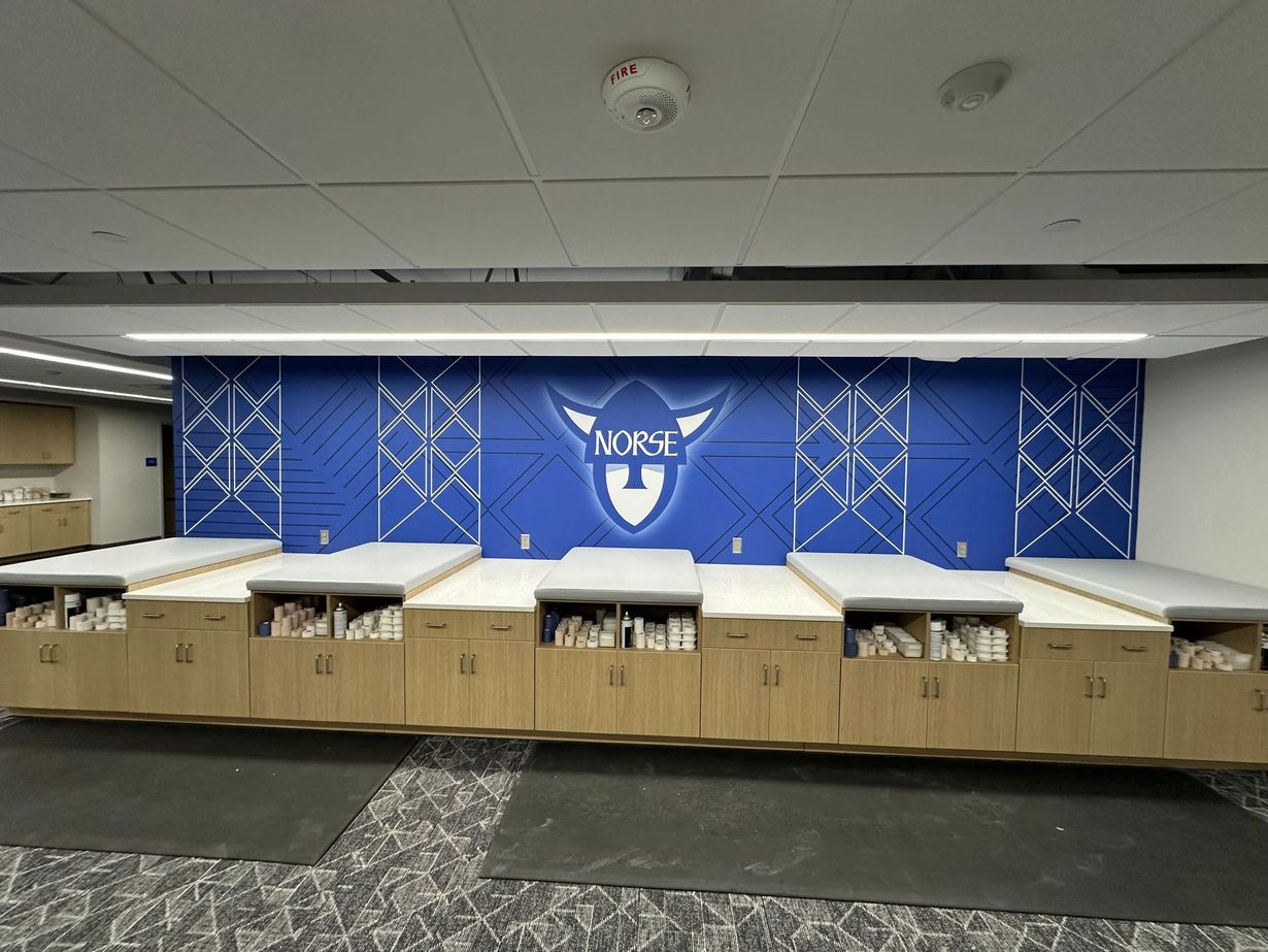 Cardboard donation bins lined up in a room beneath a blue wall with a white logo