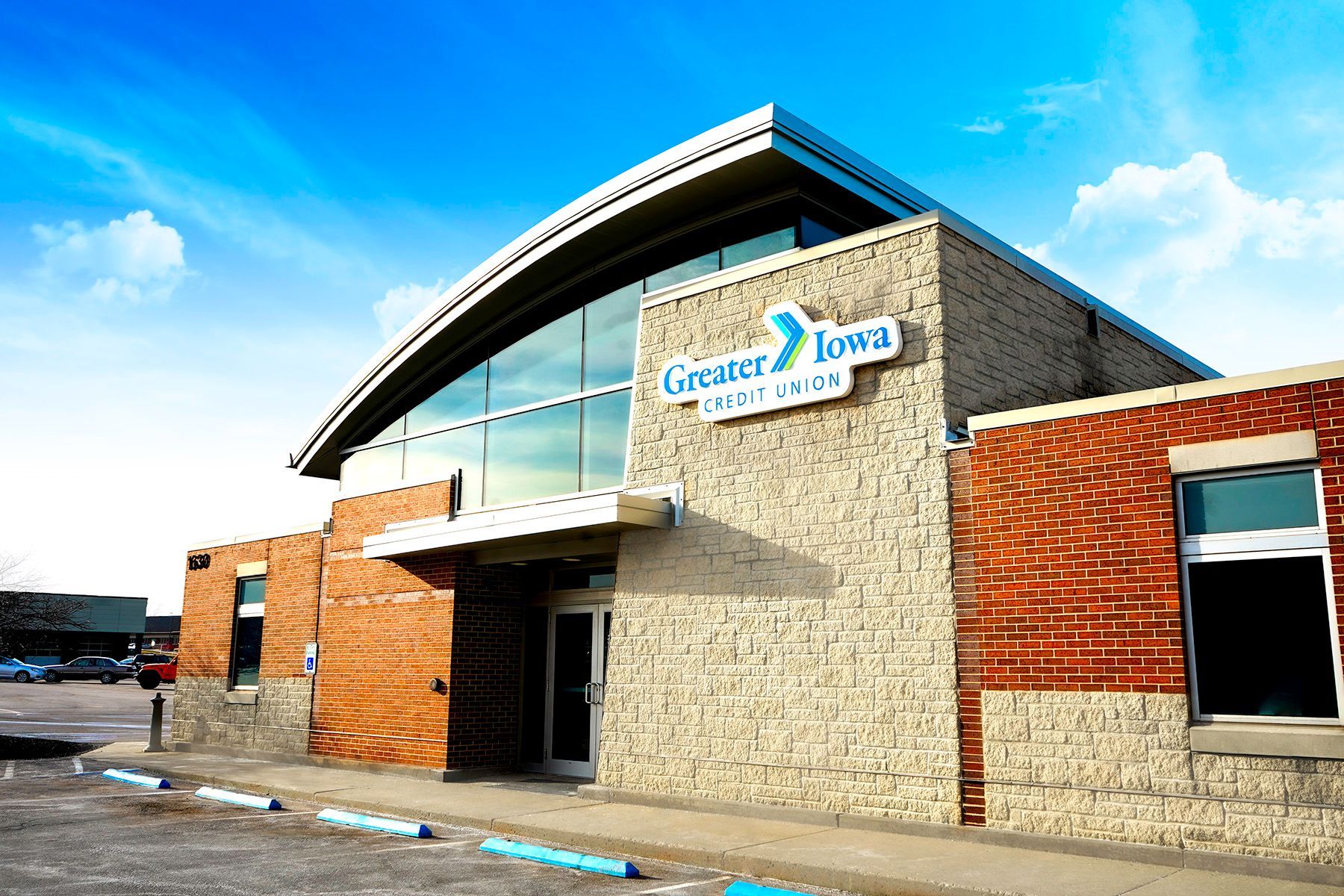 Modern building with stone and red brick exterior and a blue sky overhead