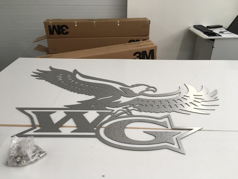 A metallic, cut-out sign of an eagle over the letters 